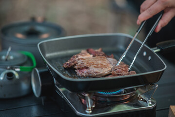 Young women enjoy to cooking meal on camping