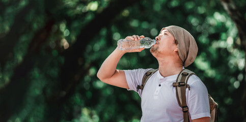 Portrait Asian traveler man with backpack drinking water