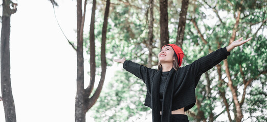 Portrait of Happy Asian young woman in winter costume at the forest with copy space