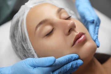 Fototapeta na wymiar Young woman receiving facial massage in salon, closeup,
