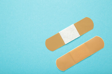 Adhesive bandage sticking plaster on blue background. Space for text