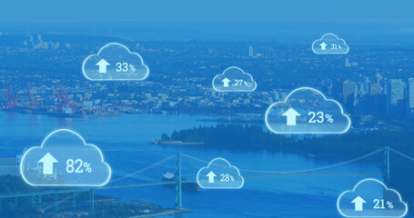 Composite of numbers with up arrow and percentage signs in clouds over aerial view of cityscape