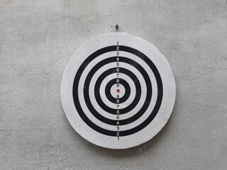 target with arrow. black white Darts board flippy knife game on the cement wall