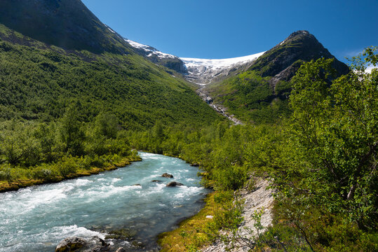 Walking through green fields and forrest along rocky trails to reach the impressive Bergsetbreen glacier in Jostedalsbreen National Park, Norway