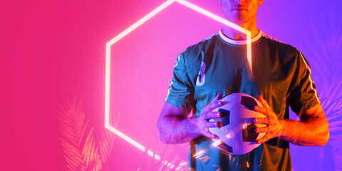 Midsection of caucasian male player holding soccer ball over illuminated plants and hexagon