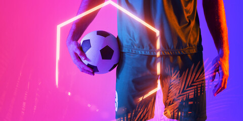 Midsection of caucasian male player holding ball over illuminated plants and hexagon, copy space