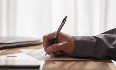 Hand of a business man writing on a document