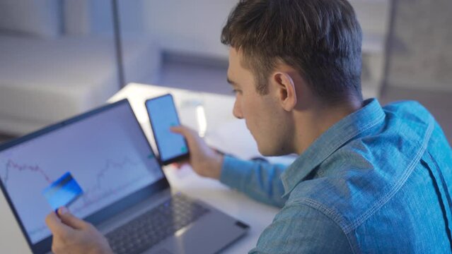 Stock market investor young man depositing money in stock market with credit card.
The man paying with a credit card is put to trade on the stock market.
