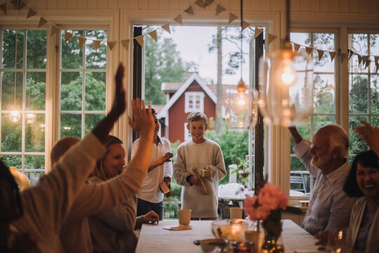 Happy Family With Hands Raised Having Fun While Playing Game During Party At Home