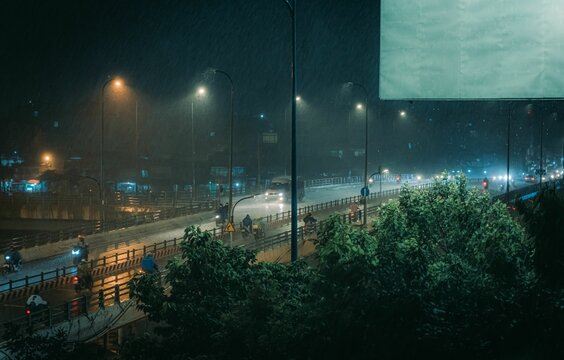 High Angle Of A Night Rainy Street View With Lights And Trees Around