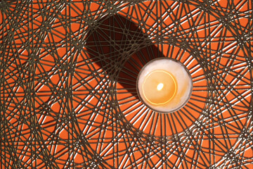 orange mandala background with white candle in the middle