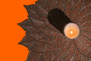 orange mandala background with white candle in the middle