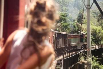 Obraz na płótnie Canvas Rear view woman tourist travel by train and exploration to landmarks in Sri Lanka. Romantic traveler lady enjoying extreme fun train ride in tropical country. Journey of world concept. Copy space
