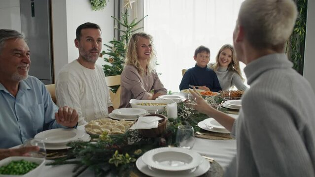 Big caucasian family sitting at the Christmas table and talking together. Shot with RED helium camera in 8K.   