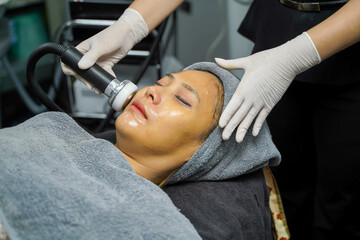 Closeup Asian beauty woman having therapy to stimulate facial skin and facial ultrasonic skincare treatment by professional cosmetologist wellbeing.