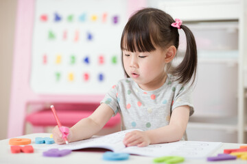 young girl practice writing letters for homeschooling