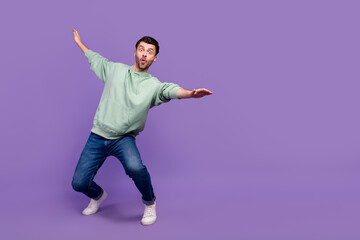 Full body photo of attractive young guy surfing falling keep balance wear trendy gray garment isolated on violet color background