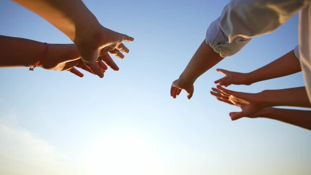 Close up many female hands raised up against blue sky. Friendly team. Gestures, symbols and signs. Participation in public vote. Swing arms to beat of music in dance. Sunny summer outdoor nature.