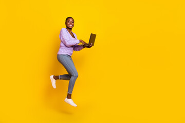 Fototapeta na wymiar Full body profile portrait of attractive active lady hold use netbook jump isolated on yellow color background