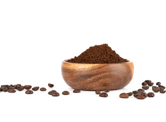 Ground coffee in a wooden bowl and coffee beans on a white background.