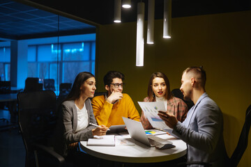 Young colleagues  in modern office discussing together work issues. Planning, study, collaborate work in teamwork. 
