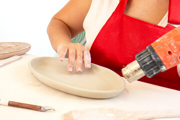 Woman potter in the process of work. Cropped image of an unrecognizable female pottery worker working with clay
