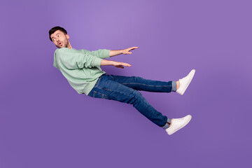 Full body photo of attractive young man wind blow away look back dressed stylish khaki garment isolated on purple color background