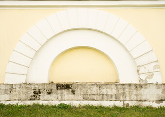 An arch on the wall near the old house. Architecture element