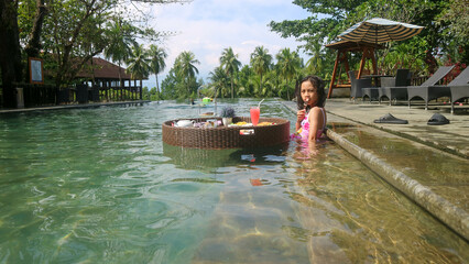 a girl having breakfast floating in the pool