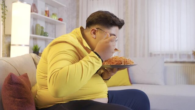 Eating pleasure of the overweight child.
Overweight boy eating pasta. He loves food.
