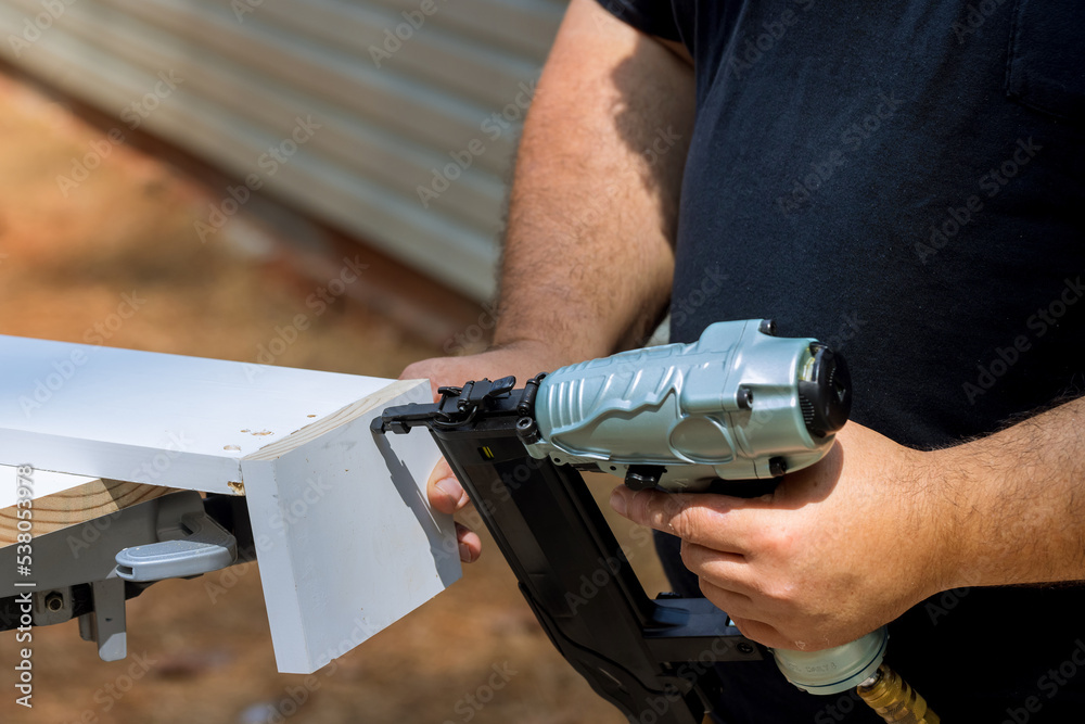 Wall mural With help of pneumatic air gun carpenter connects assembly for wood boards with nails