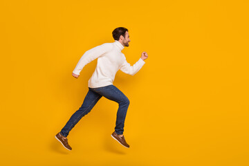 Fototapeta na wymiar Photo of sweet attractive guy wear white pullover jumping high running fast isolated yellow color background
