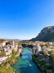 Photo sur Plexiglas Stari Most Vertical scenery of the Mostar Bridge over the river Neretva surrounded by beautiful cityscape
