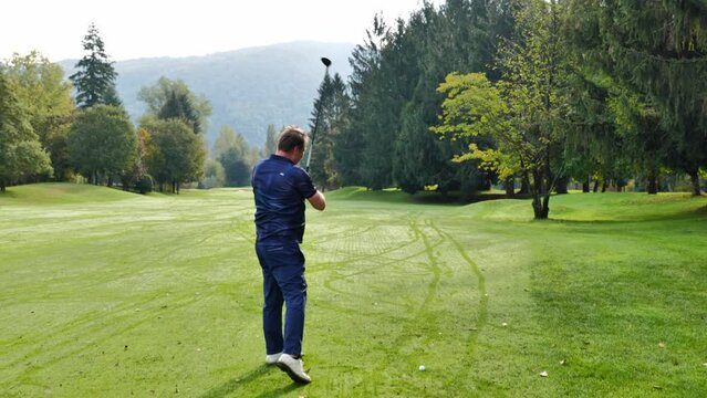 Golfer Hitting the Golf Ball on the Fairway with Sunlight in Switzerland.