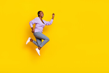 Fototapeta na wymiar Full length profile portrait of active sporty lady run jump look empty space isolated on yellow color background