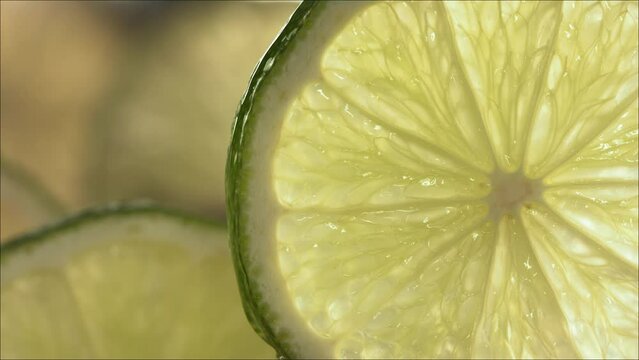 Drop of water flow down the surface of a ripe juicy Lime slice. Slow Motion 4K