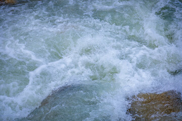 Mountain bubbling water in the river close-up.