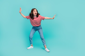 Full length photo of shiny excited girl dressed red t-shirt surfing looking empty space isolated teal color background