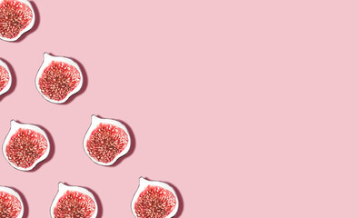 Figs. Minimal style. Top view. Halved ripe fresh fruits on pink desk 