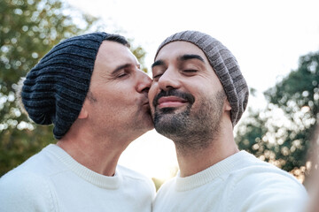 Happy mature gay men couple having fun making selfie outdoor - Lgbtq love concept - Powered by Adobe