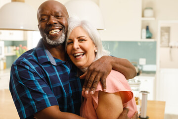 Portrait of happy senior diverse couple embracing