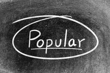 Obraz premium White chalk hand writing in word popular and circle shape on blackboard background