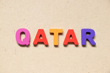 Color alphabet letter in word qatar on wood background