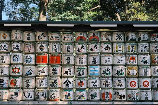Wall of Japanese wine jars of traditional alcohol brands in Menji with different signs and images