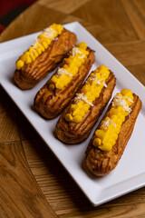 eclairs on a white plate in a restaurant
