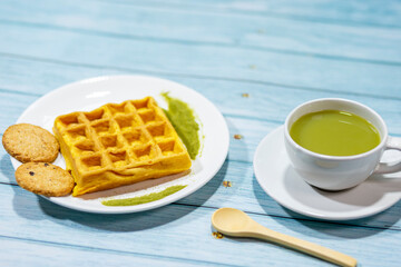 Today's breakfast, green tea, milk, and waffle cookies on the kitchen table.