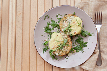 Vegetarian frittata muffins with almond flakes, tofu, pea sprouts, greens, vegetables. Healthy food on a wooden table.
