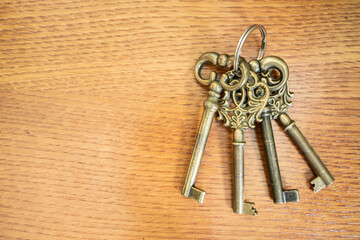 Three antique keys on old steel metal texture background