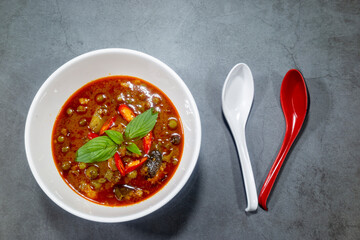 For dinner today, spicy Thai food red curry served on the table is dinner and a spoon.