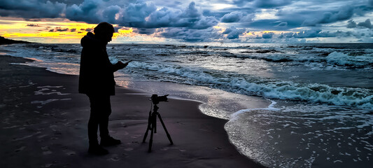 Sunset over Baltic Sea with photographer and oil platform in background - Lubiatowo, Pomerania, Poland